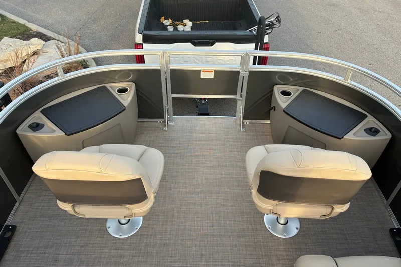 Slide: The Image of 2025 Sun Tracker Fishin' Barge 20 DLX interior with beige seats and fishing stations. - 17