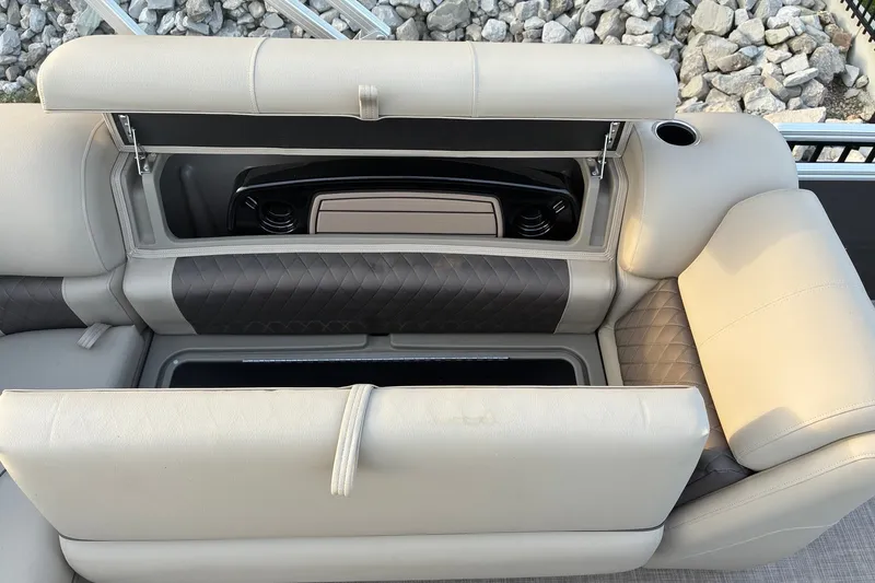 Slide: The Image of 2025 Sun Tracker Fishin' Barge 20 DLX seating with storage compartment open, showcasing luxury design. - 15