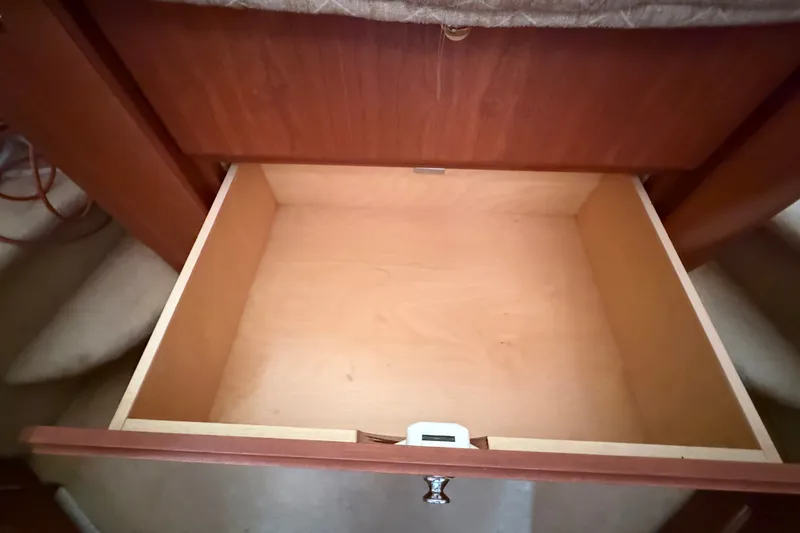 Slide: The Image of Empty wooden drawer inside a 2004 Silverton 43 Motor Yacht, showcasing interior storage space. - 122