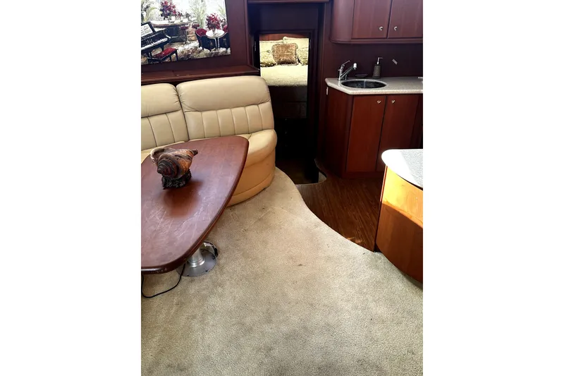 Slide: The Image of Interior of 2004 Silverton 43 Motor Yacht with beige seating and wooden table. - 5