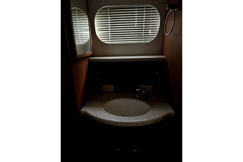 Slide: The Image of 2004 Silverton 43 Motor Yacht bathroom with sink, mirror, and window blinds. - 24