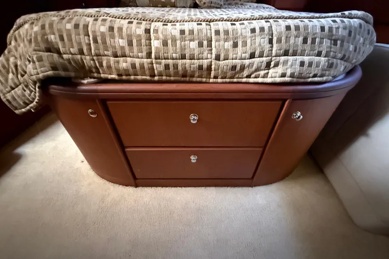 Slide: The Image of 2004 Silverton 43 Motor Yacht interior with wooden storage drawers under bed. - 155