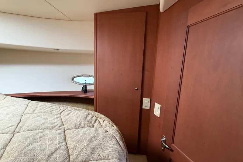 Slide: The Image of Interior of 2004 Silverton 43 Motor Yacht with wood paneling and cozy bedding. - 127