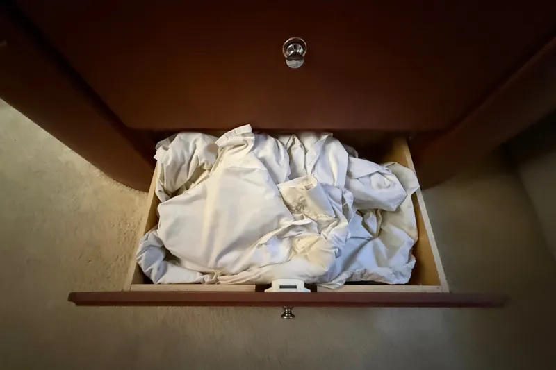 Slide: The Image of Open drawer with crumpled white linens inside a 2004 Silverton 43 Motor Yacht. - 157