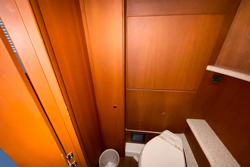 Slide: The Image of 2004 Silverton 43 Motor Yacht bathroom with wooden cabinetry and compact toilet. - 149