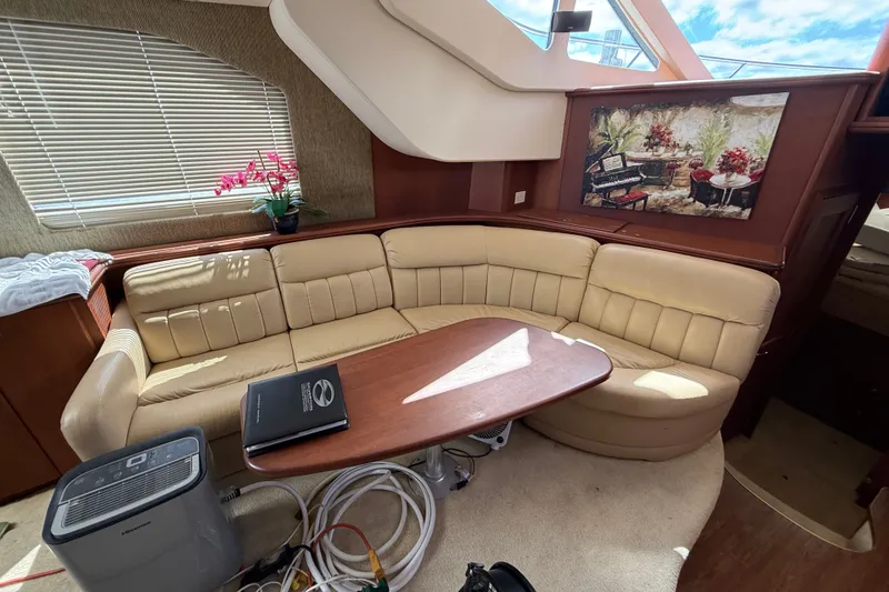 Slide: The Image of Interior of 2004 Silverton 43 Motor Yacht with beige seating and wooden table. - 88
