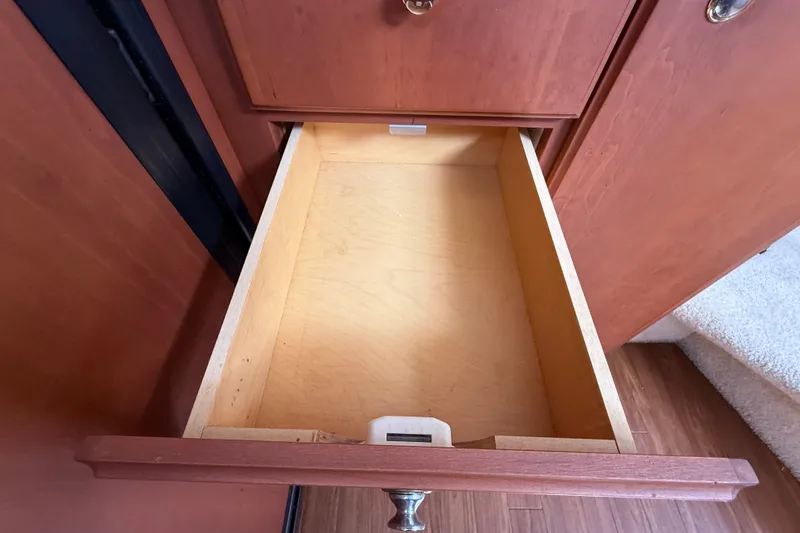 Slide: The Image of Open wooden drawer inside a 2004 Silverton 43 Motor Yacht, showcasing interior storage. - 94