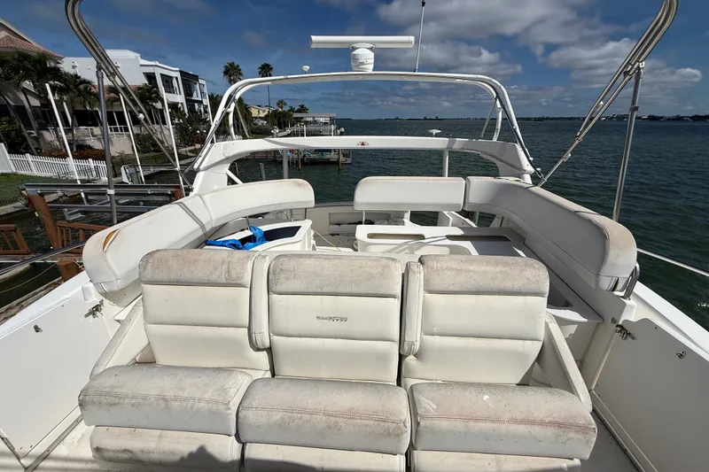 Slide: The Image of 2004 Silverton 43 Motor Yacht with spacious seating, docked by waterfront homes. - 65