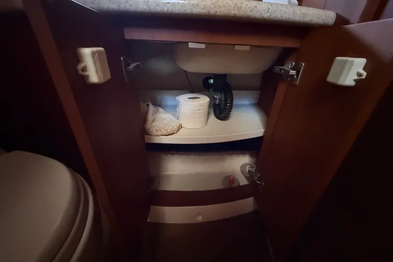 Slide: The Image of Open cabinet under sink in 2004 Silverton 43 Motor Yacht bathroom. - 116