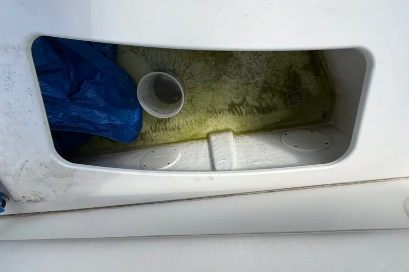 Slide: The Image of Storage compartment of a 2004 Silverton 43 Motor Yacht with blue tarp and cup. - 23