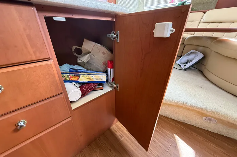 Slide: The Image of Open cabinet in 2004 Silverton 43 Motor Yacht, revealing stored items and fan nearby. - 96