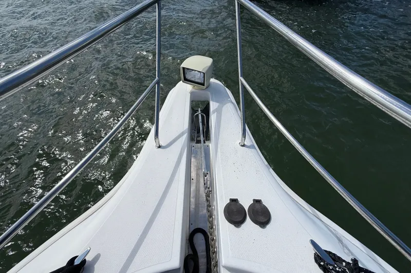 Slide: The Image of Bow view of 2004 Silverton 43 Motor Yacht on water, featuring railing and anchor. - 53