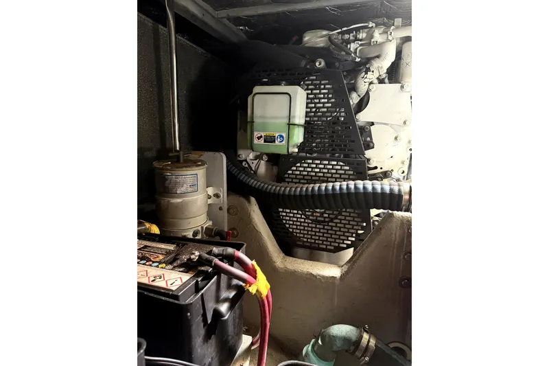 Slide: The Image of Engine compartment of a 2004 Silverton 43 Motor Yacht, showcasing mechanical components and battery. - 14