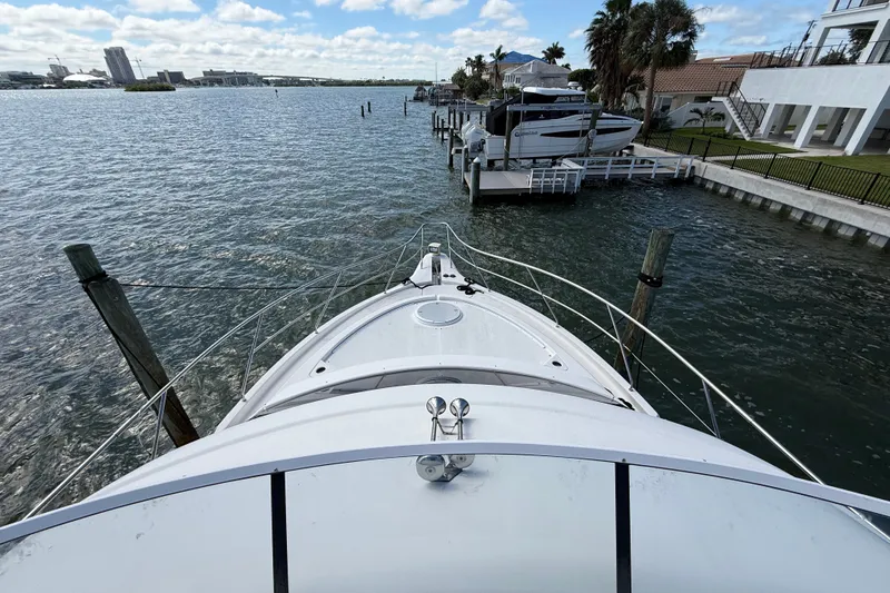 Slide: The Image of Bow view of 2004 Silverton 43 Motor Yacht docked by waterfront homes. - 38