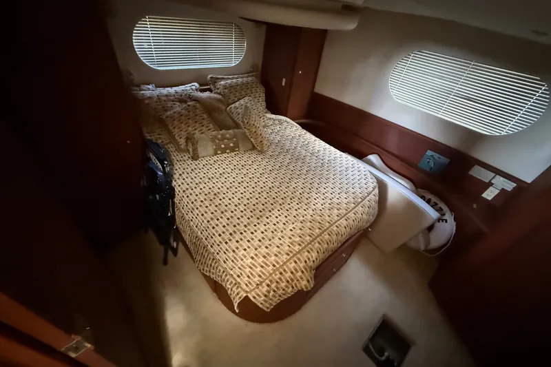 Slide: The Image of Cozy bedroom in 2004 Silverton 43 Motor Yacht with patterned bedding and oval windows. - 140