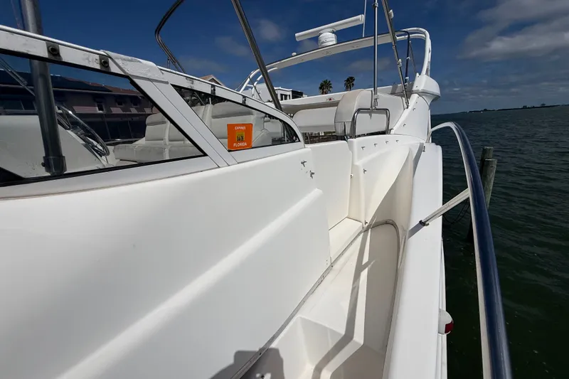 Slide: The Image of 2004 Silverton 43 Motor Yacht docked, showcasing sleek white exterior and spacious deck. - 62