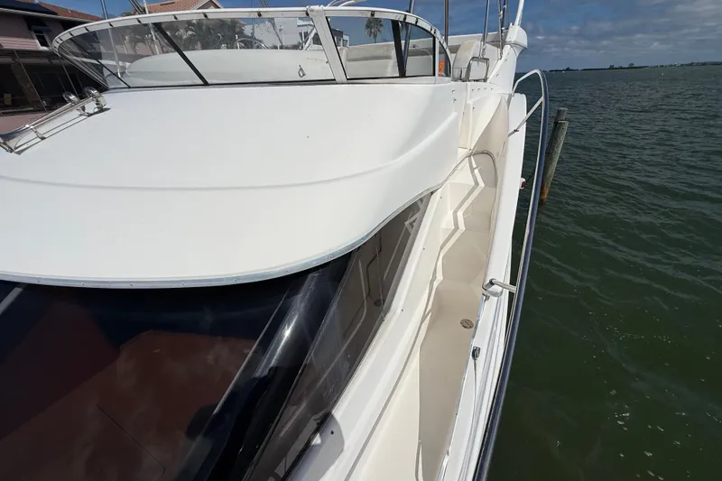 Slide: The Image of 2004 Silverton 43 Motor Yacht on calm waters, showcasing sleek design and spacious deck. - 60