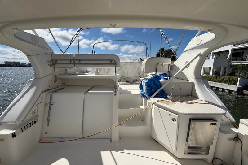 Slide: The Image of 2004 Silverton 43 Motor Yacht deck with seating and kitchenette, overlooking waterfront. - 10
