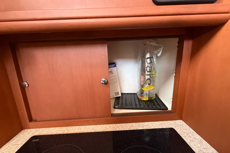 Slide: The Image of Cabinet interior on 2004 Silverton 43 Motor Yacht with plastic cups and a box. - 98