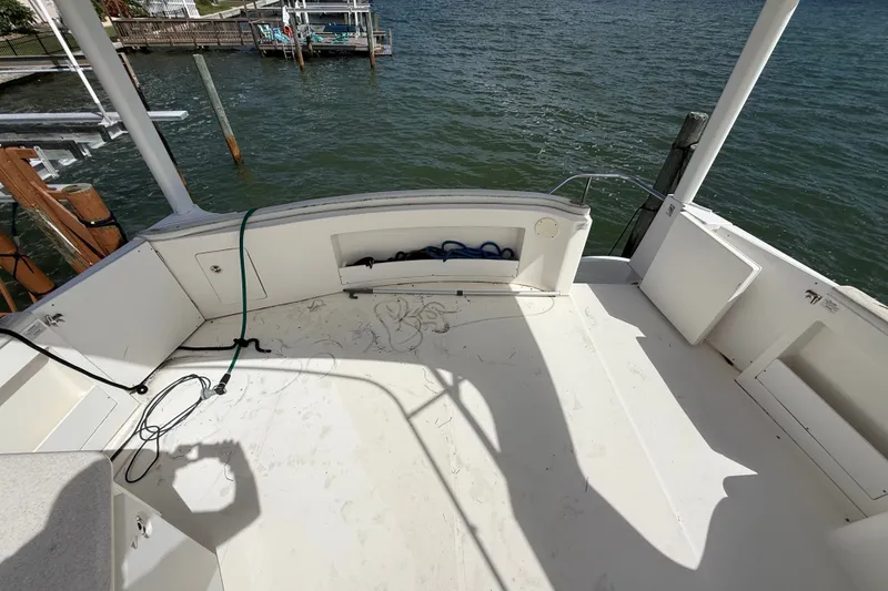 Slide: The Image of 2004 Silverton 43 Motor Yacht deck overlooking water, featuring storage compartments and dock view. - 74