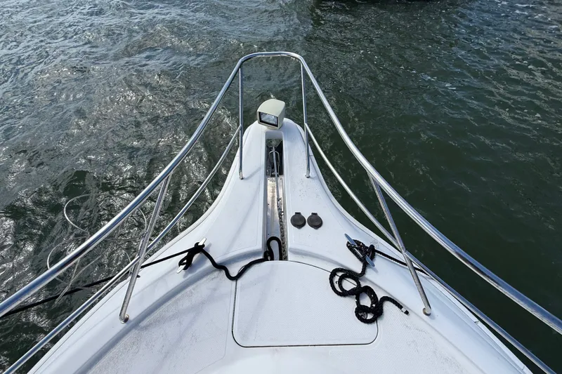 Slide: The Image of Bow view of 2004 Silverton 43 Motor Yacht on water, featuring railings and ropes. - 51