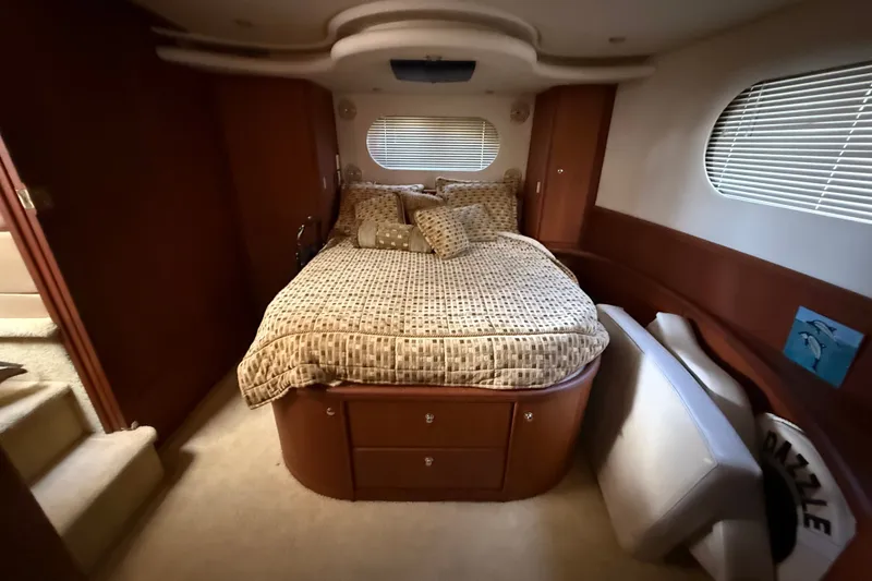 Slide: The Image of Luxurious bedroom interior of 2004 Silverton 43 Motor Yacht with cozy bedding and elegant wood finish. - 154