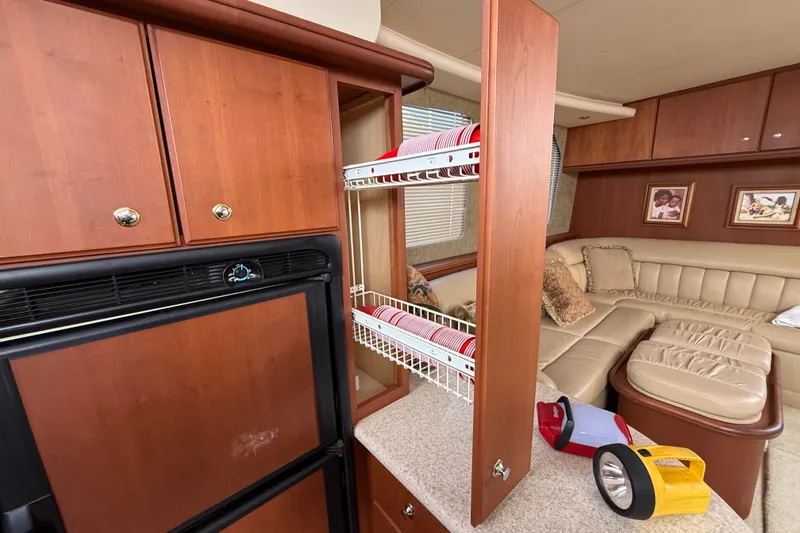 Slide: The Image of Interior of 2004 Silverton 43 Motor Yacht with wooden cabinets and cozy seating area. - 90