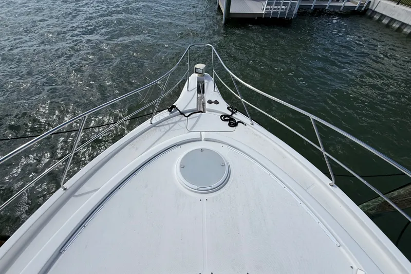 Slide: The Image of Bow view of 2004 Silverton 43 Motor Yacht docked by the water. - 49