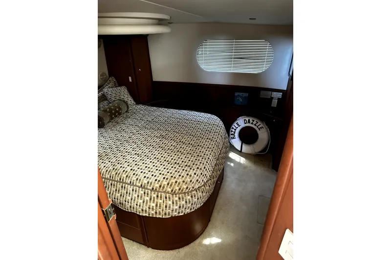 Slide: The Image of Interior cabin of 2004 Silverton 43 Motor Yacht with patterned bedding and porthole window. - 7