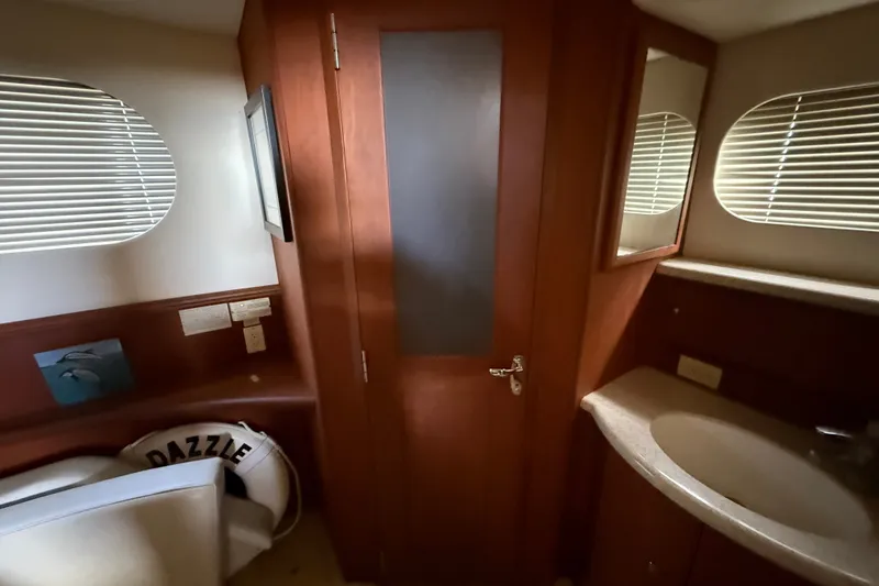 Slide: The Image of Interior of 2004 Silverton 43 Motor Yacht bathroom with wooden cabinetry and sink. - 151