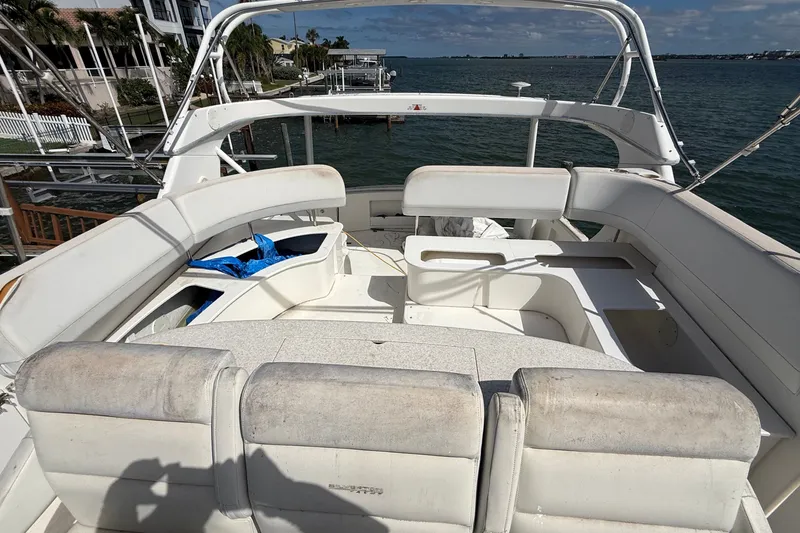 Slide: The Image of 2004 Silverton 43 Motor Yacht deck with white seating, overlooking calm waters. - 66
