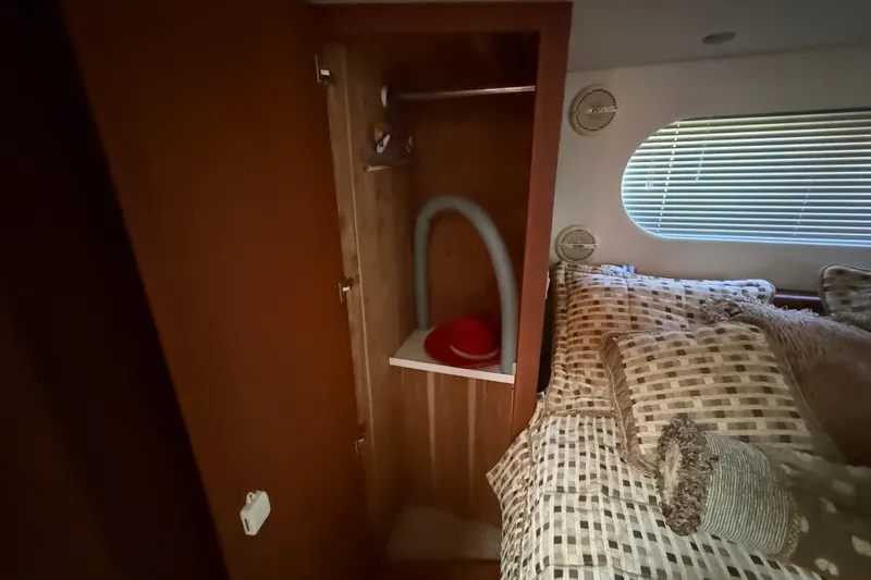 Slide: The Image of Interior of 2004 Silverton 43 Motor Yacht with cozy bed and wooden closet. - 164