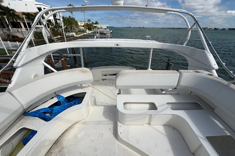 Slide: The Image of 2004 Silverton 43 Motor Yacht deck with seating, overlooking serene waterfront view. - 69