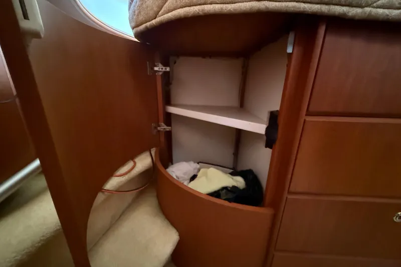 Slide: The Image of Interior storage cabinet on 2004 Silverton 43 Motor Yacht, featuring wooden finish and shelving. - 125