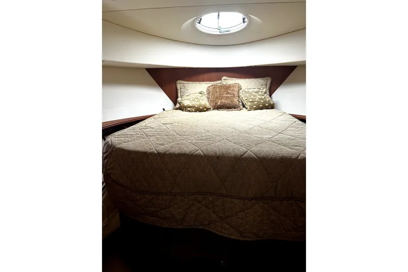 Slide: The Image of Luxurious bedroom interior of 2004 Silverton 43 Motor Yacht with elegant bedding and porthole. - 8