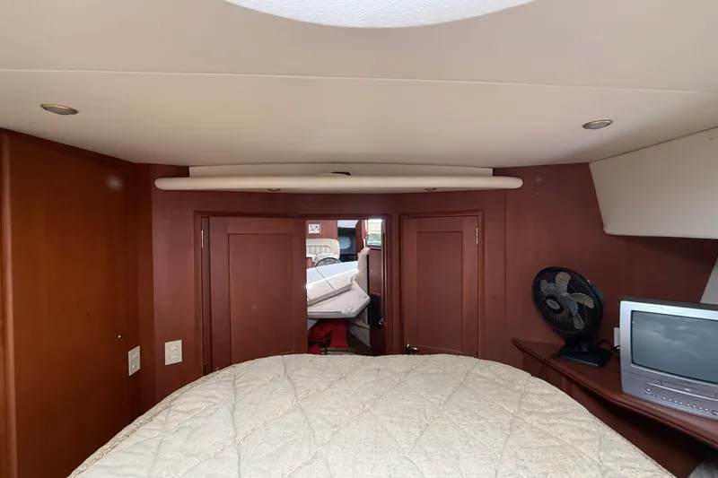 Slide: The Image of Interior of 2004 Silverton 43 Motor Yacht bedroom with TV and fan. - 131