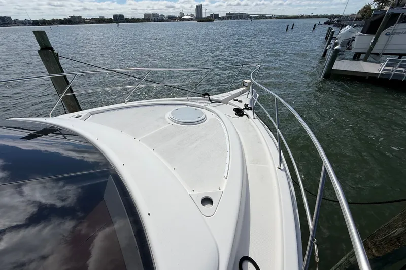 Slide: The Image of 2004 Silverton 43 Motor Yacht docked by the water, showcasing its sleek deck design. - 48