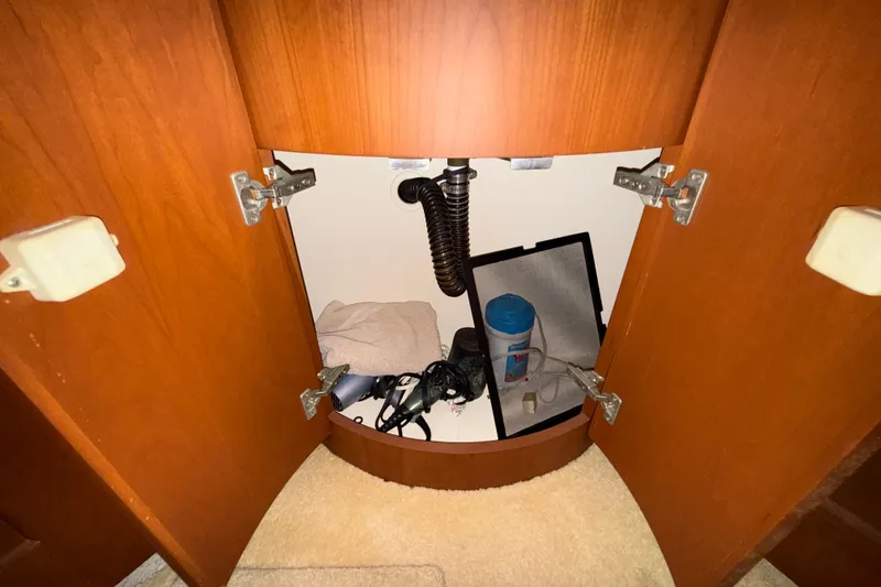 Slide: The Image of Open cabinet under sink in 2004 Silverton 43 Motor Yacht, showing storage items. - 148