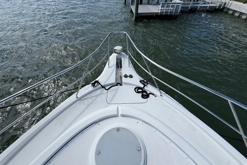 Slide: The Image of Bow view of 2004 Silverton 43 Motor Yacht docked by the water. - 50