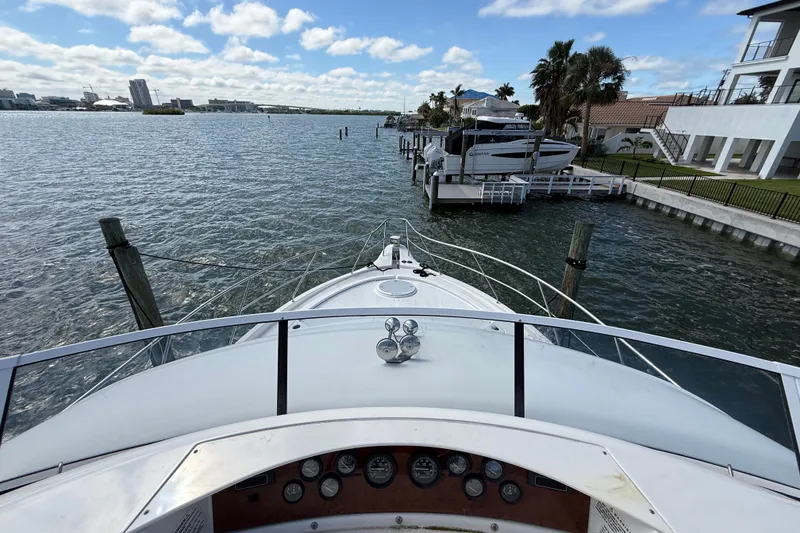 Slide: The Image of Bow view from 2004 Silverton 43 Motor Yacht docked by waterfront homes. - 37