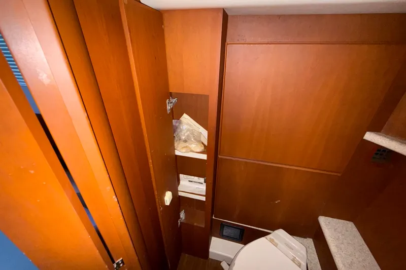 Slide: The Image of Interior of 2004 Silverton 43 Motor Yacht bathroom with wooden cabinetry and shelves. - 150