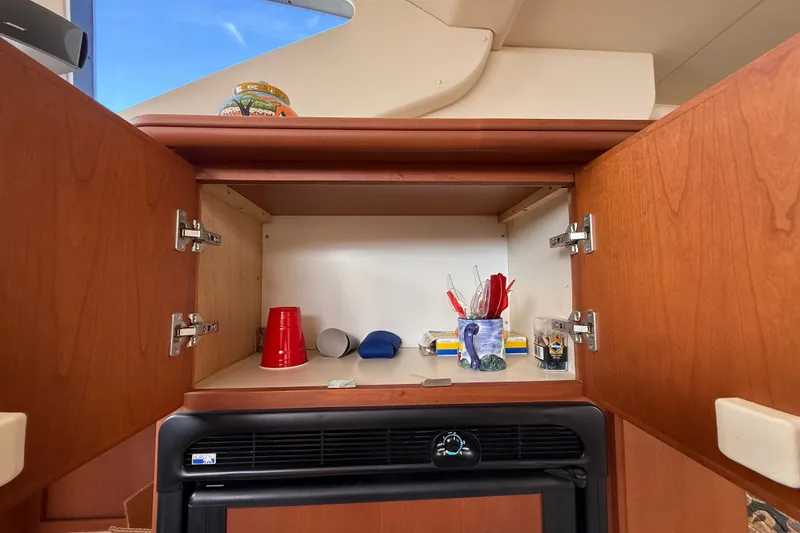 Slide: The Image of Open cabinet in 2004 Silverton 43 Motor Yacht with cups and utensils inside. - 91