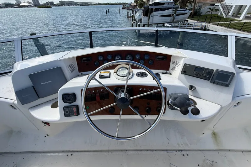 Slide: The Image of 2004 Silverton 43 Motor Yacht helm with steering wheel and navigation controls. - 28