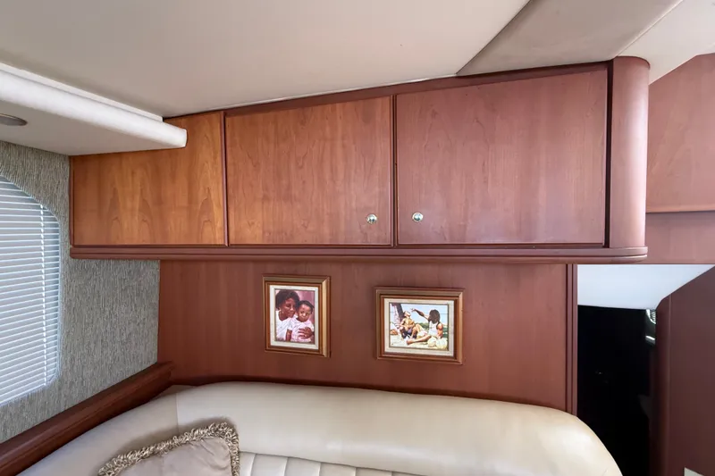 Slide: The Image of Interior of 2004 Silverton 43 Motor Yacht with wood cabinets and framed photos. - 136