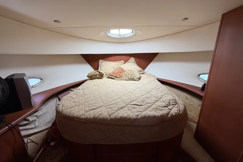 Slide: The Image of 2004 Silverton 43 Motor Yacht bedroom with cozy bedding and porthole windows. - 119