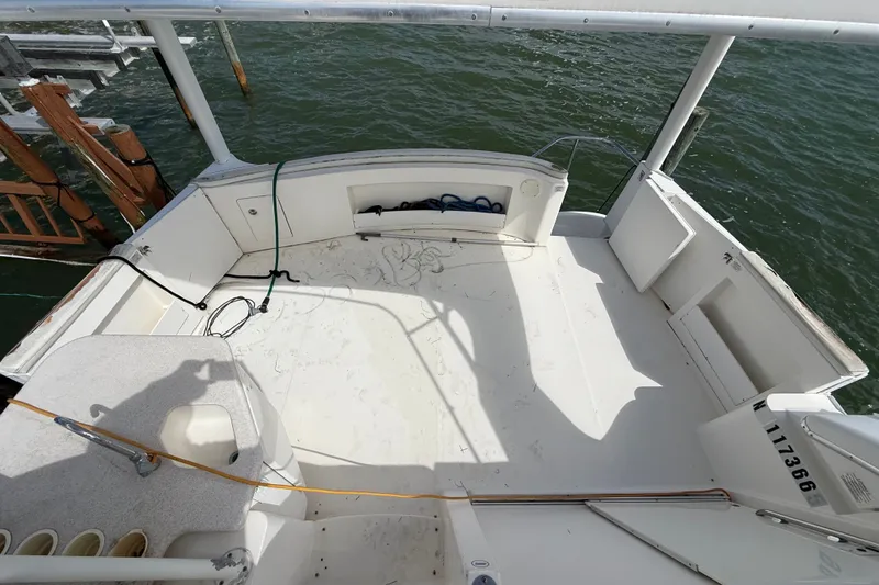 Slide: The Image of 2004 Silverton 43 Motor Yacht deck with railing, docked by the water. - 73