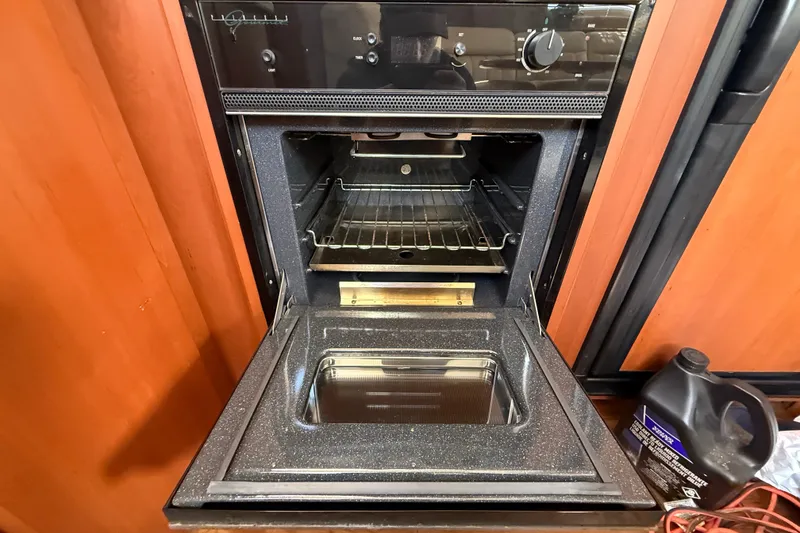 Slide: The Image of Open oven inside a 2004 Silverton 43 Motor Yacht, with wooden cabinetry. - 102