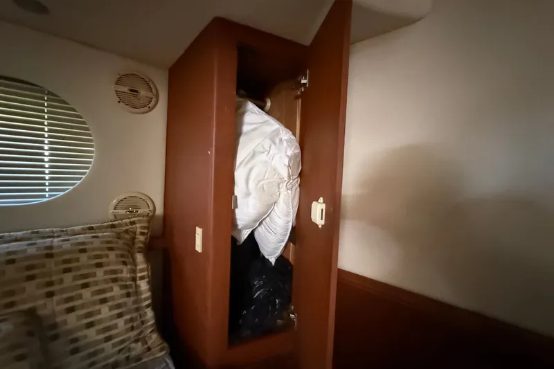 Slide: The Image of Interior of 2004 Silverton 43 Motor Yacht showing open closet with bedding. - 162