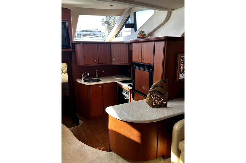 Slide: The Image of Luxurious 2004 Silverton 43 Motor Yacht interior with elegant wood cabinetry and modern kitchen amenities. - 10