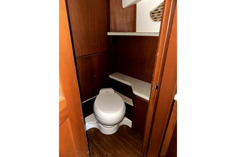 Slide: The Image of 2004 Silverton 43 Motor Yacht bathroom with wooden cabinetry and compact toilet. - 11